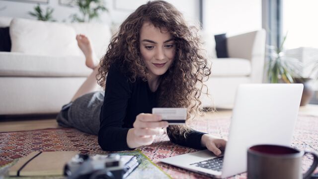 A young teenage girl with laptop, camera and map holding a card SMALL
